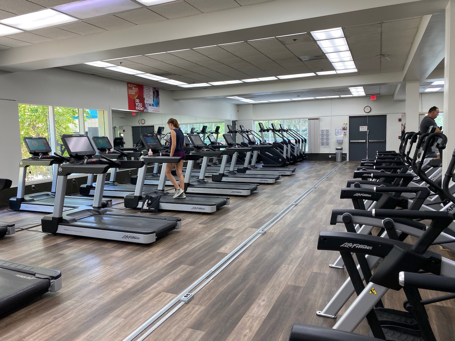 a woman standing on treadmills in a gym