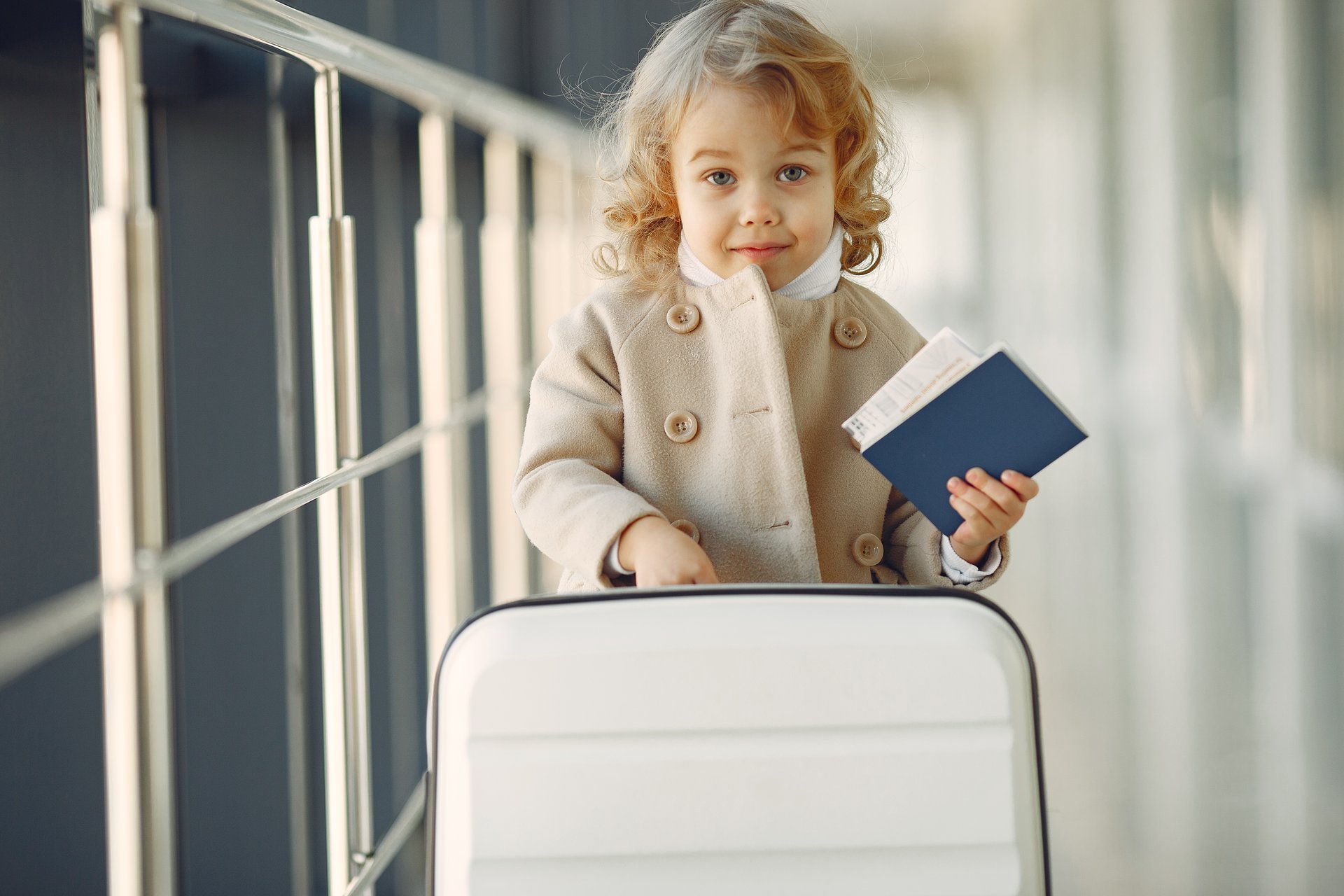 a child holding a book and a suitcase