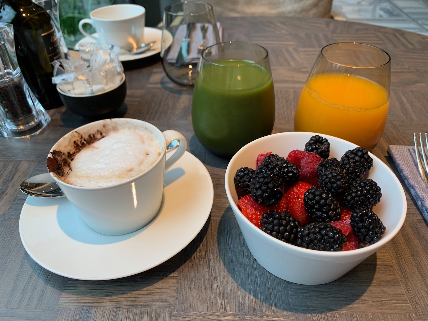 a bowl of fruit and a drink on a table