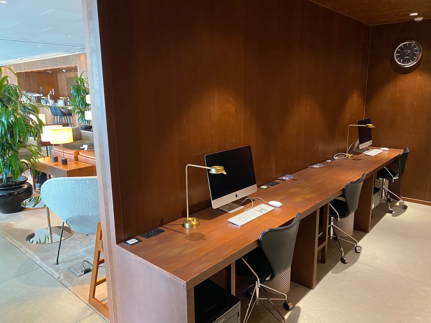 a desk with computers and chairs in a room