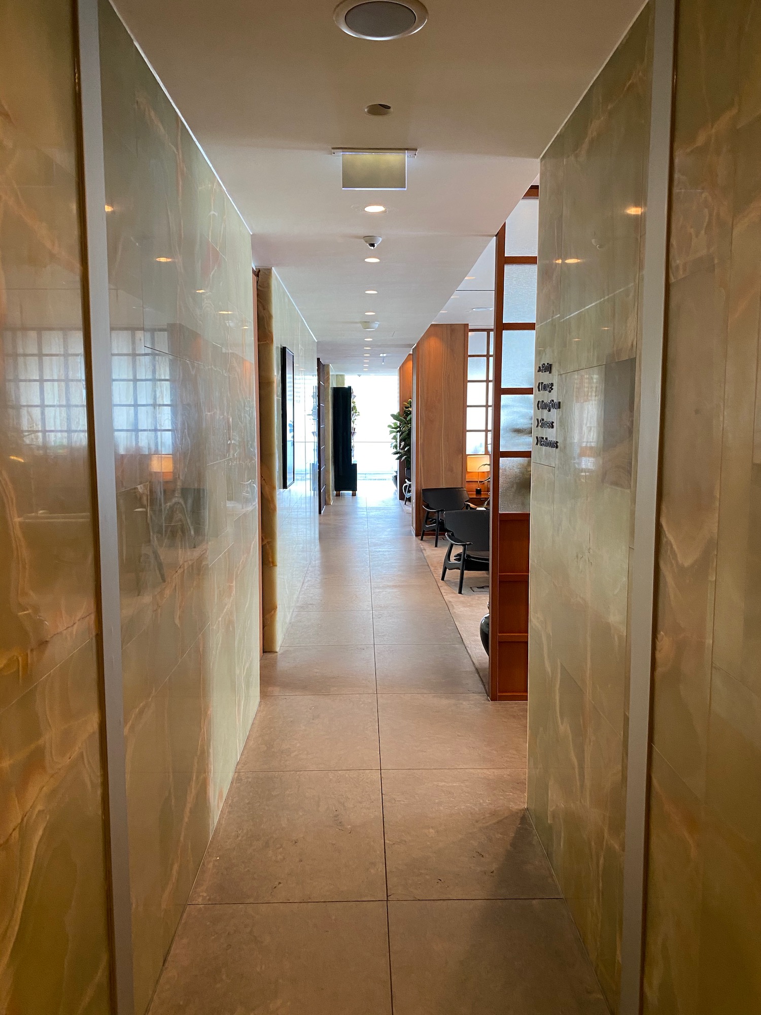 a hallway with marble walls and a window