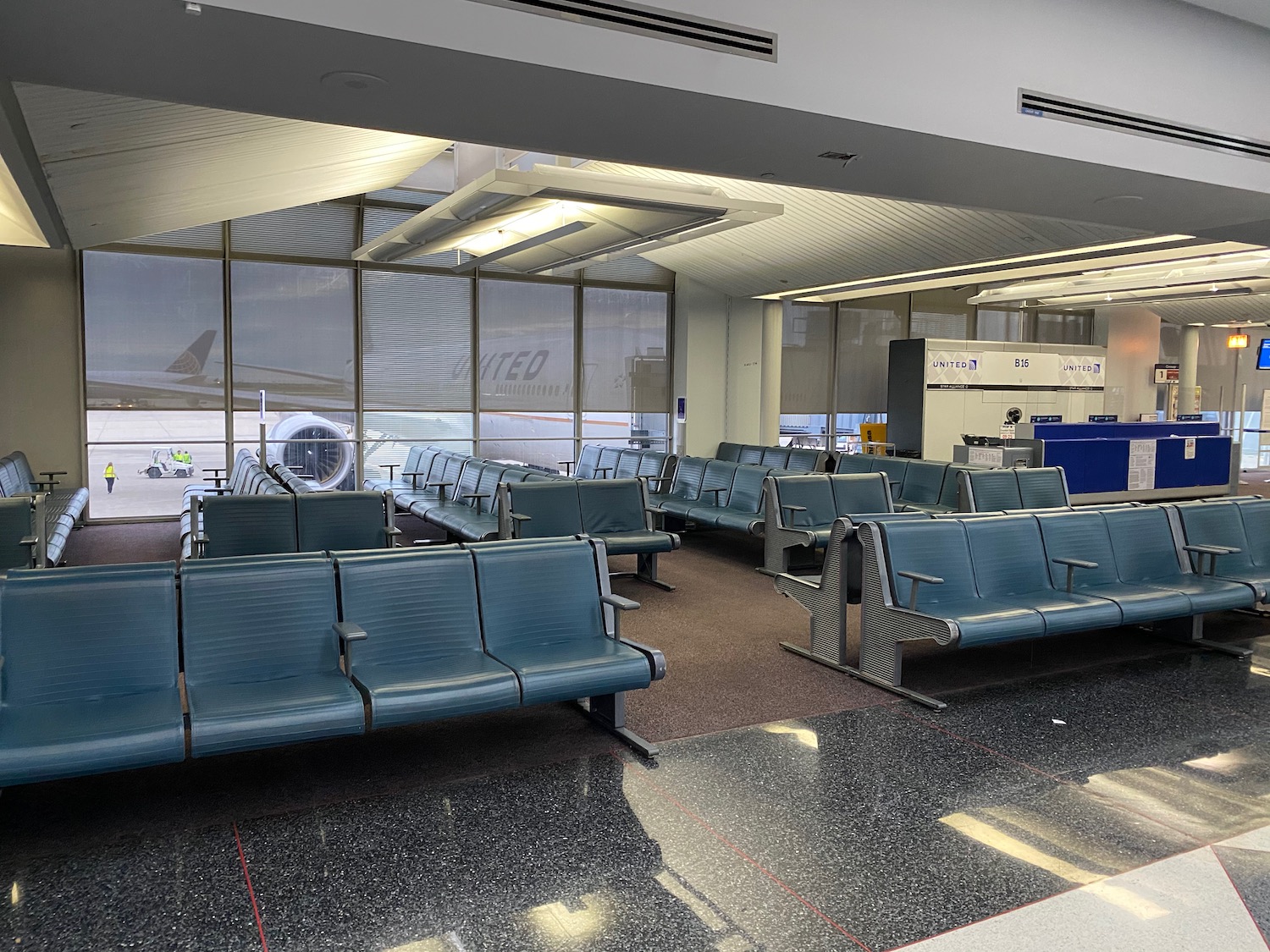 a row of blue chairs in an airport terminal