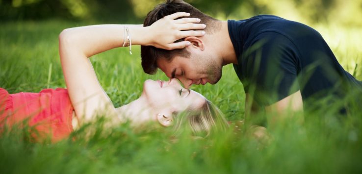 a man and woman lying in grass