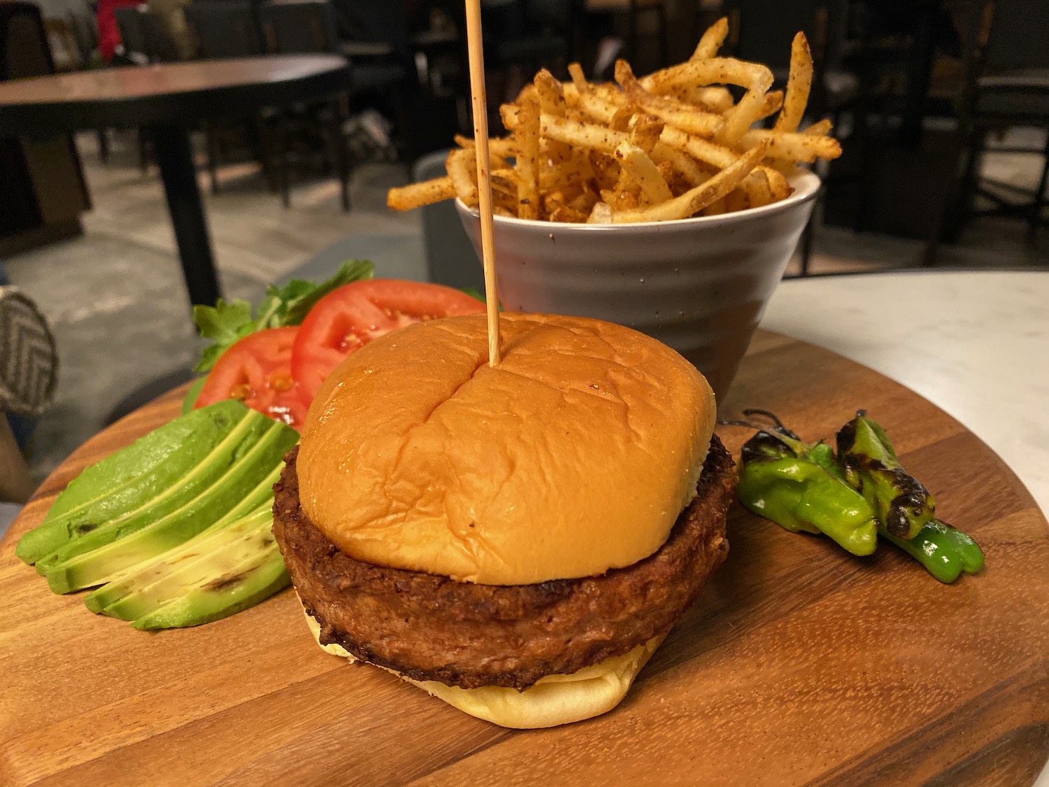 a burger and fries on a wooden board