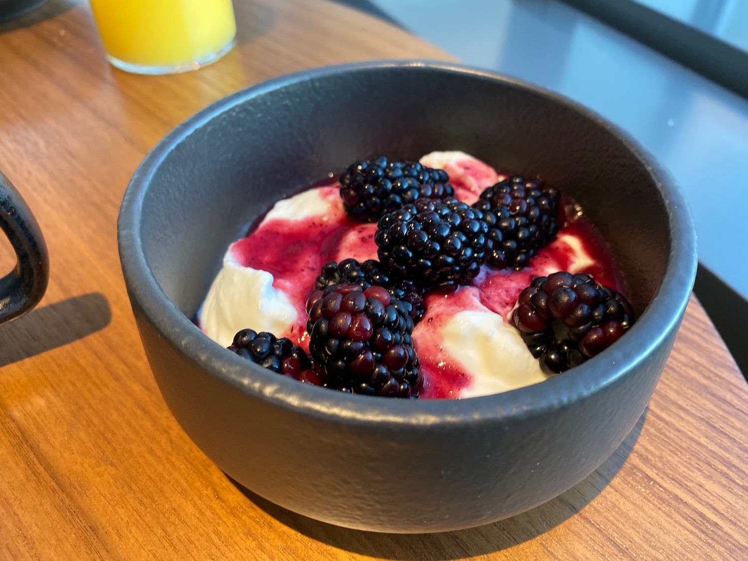 a bowl of food with blackberries and cream