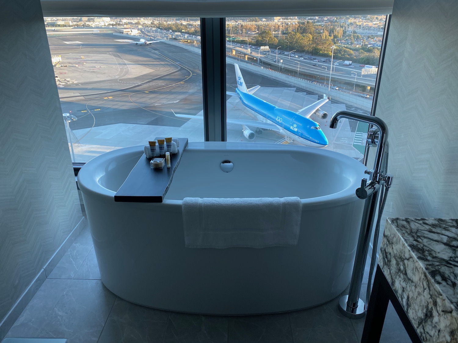 a bathtub with a window and a plane in the background