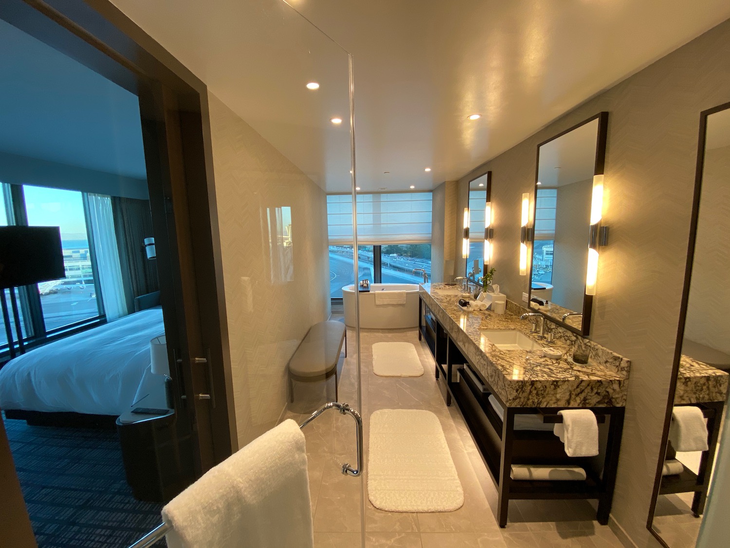 a bathroom with a glass shower and a large mirror