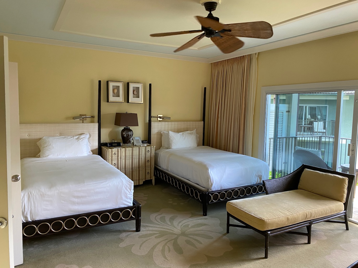 a room with two beds and a fan