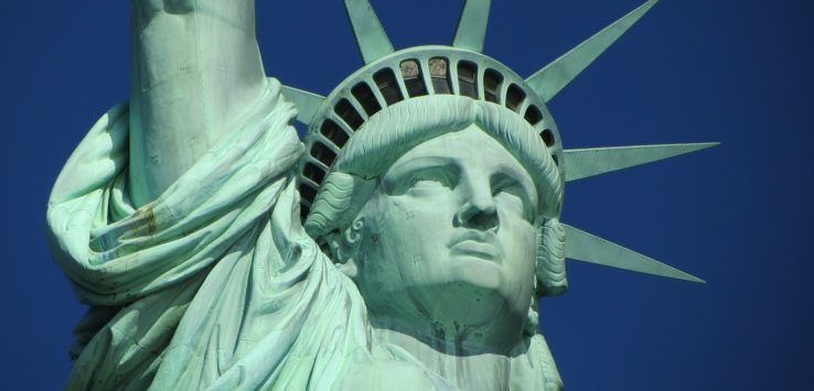 a close up of a statue with Statue of Liberty in the background