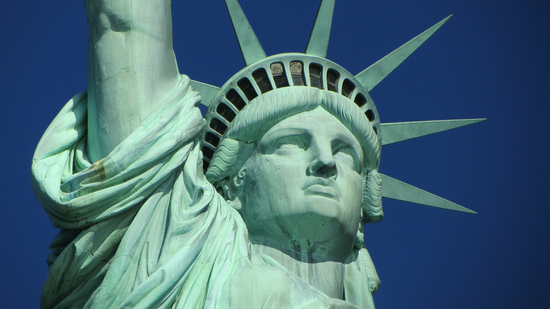 a close up of a statue with Statue of Liberty in the background