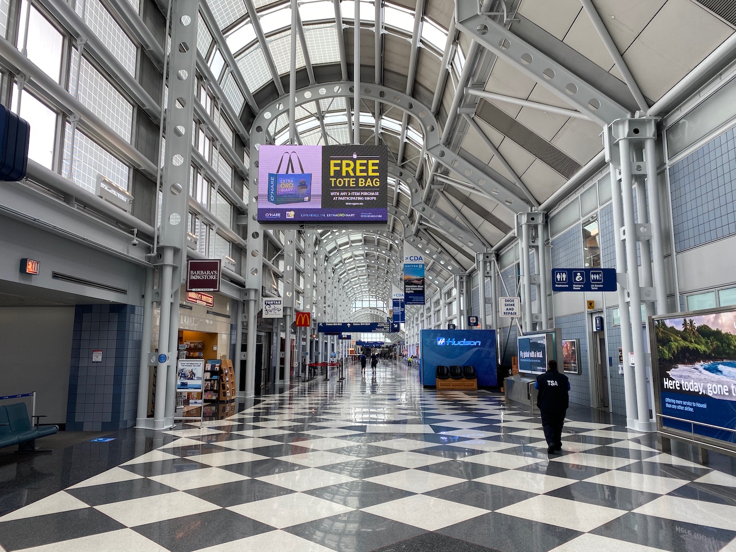 a black and white checkered floor with signs and people walking