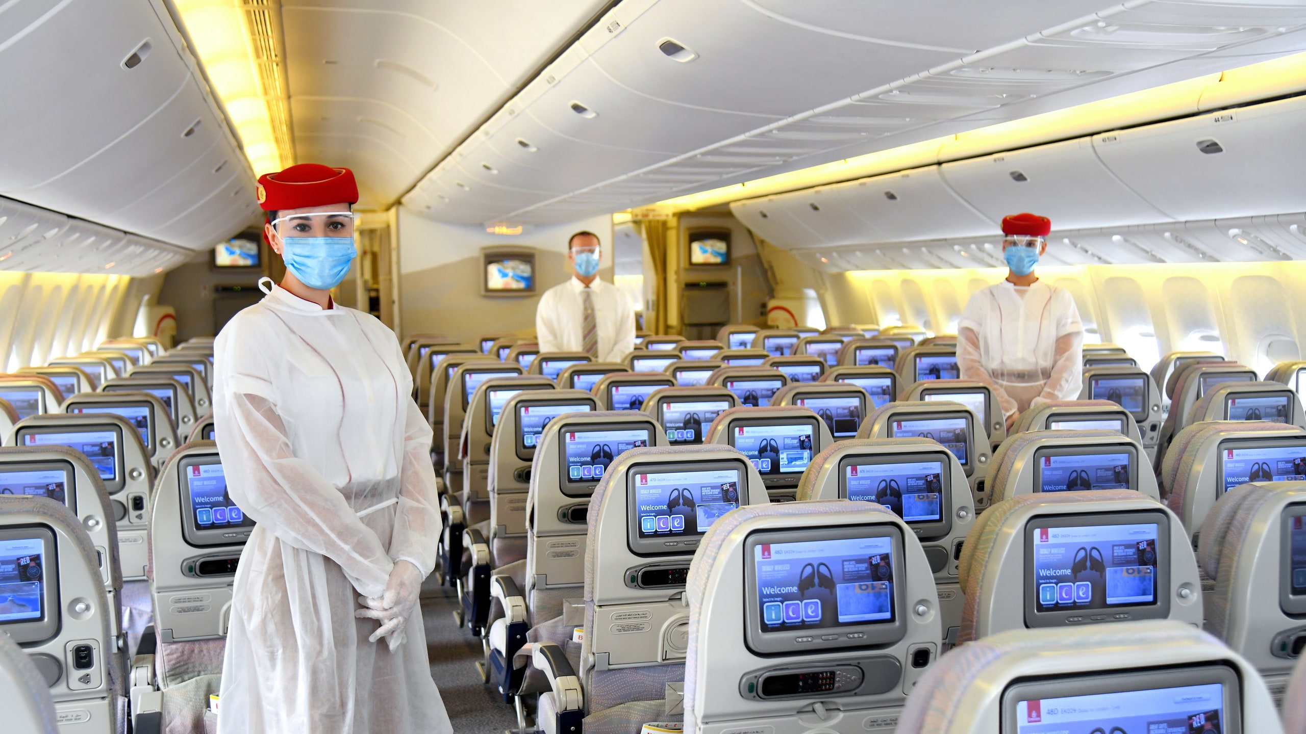 a group of people wearing face masks and standing in an airplane