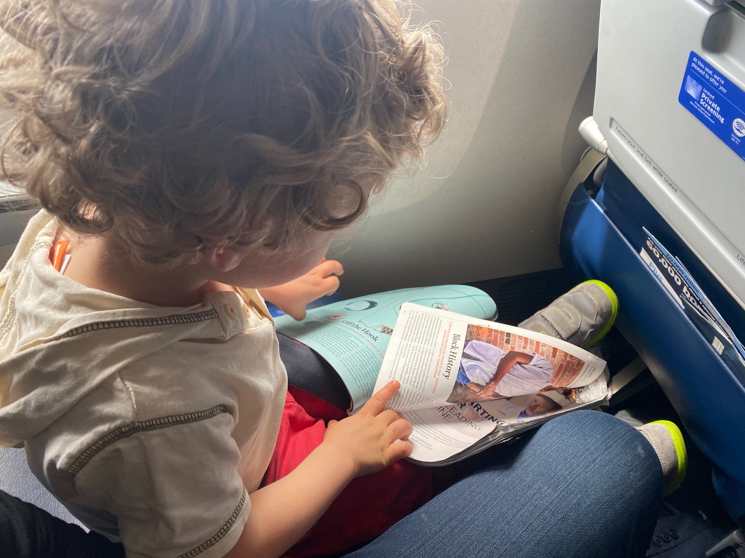 a child reading a magazine on an airplane