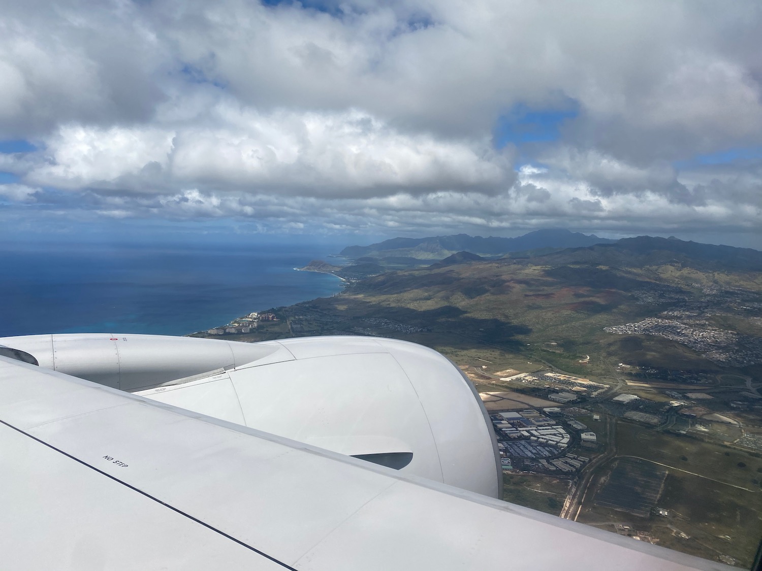 an airplane wing and view of land and mountains