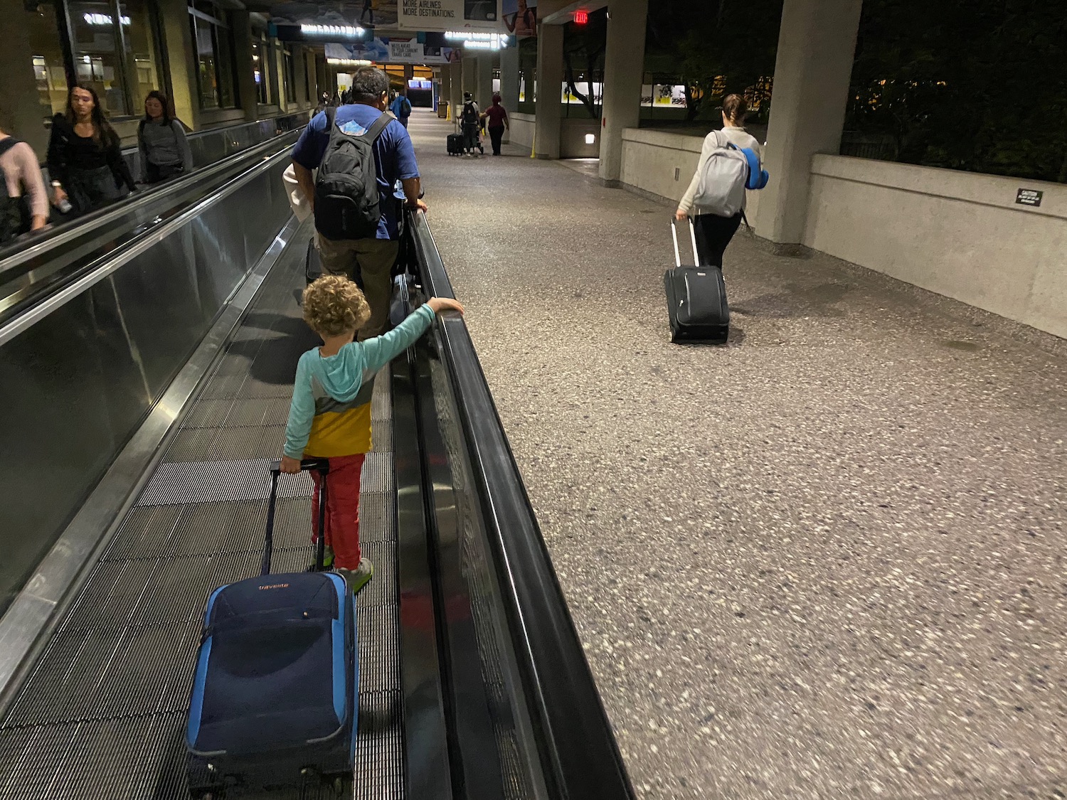 a group of people with luggage on an escalator