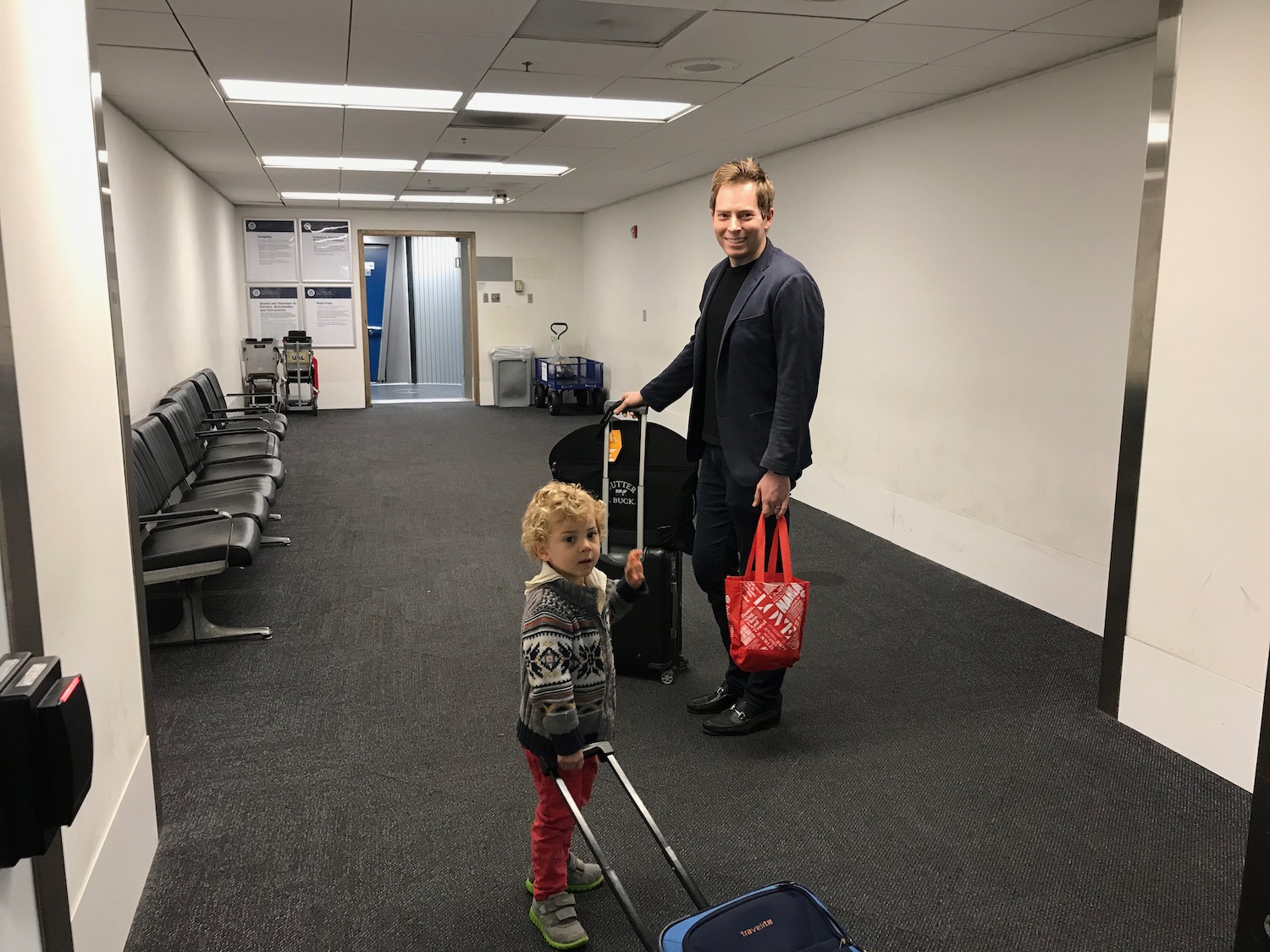 a man and child with luggage in an airport