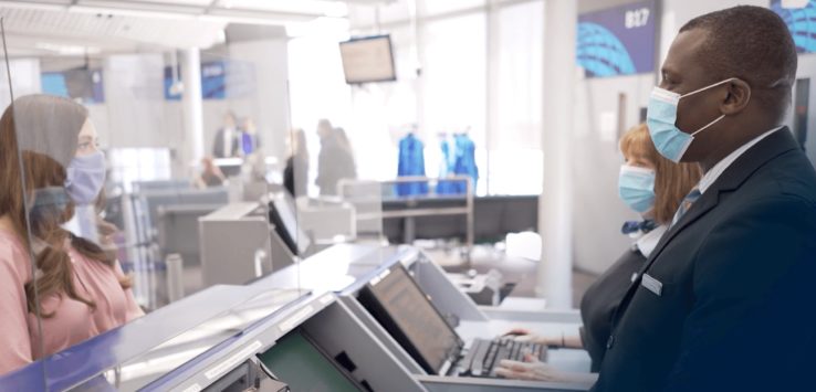 a woman wearing a mask and using a computer