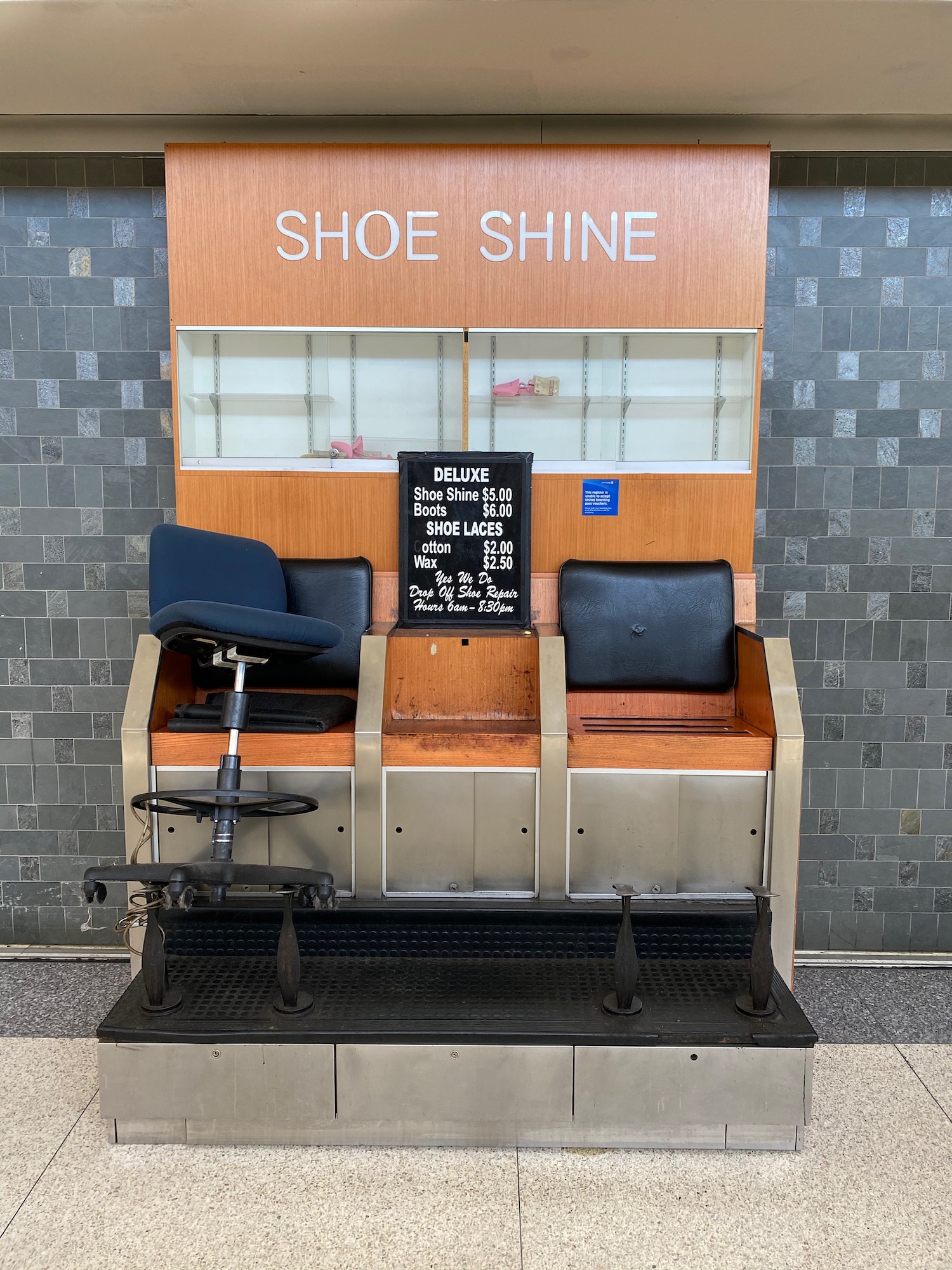 a shoe shine booth with a chair and a sign