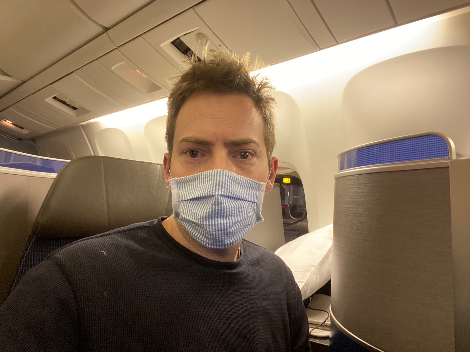 a man wearing a mask on an airplane