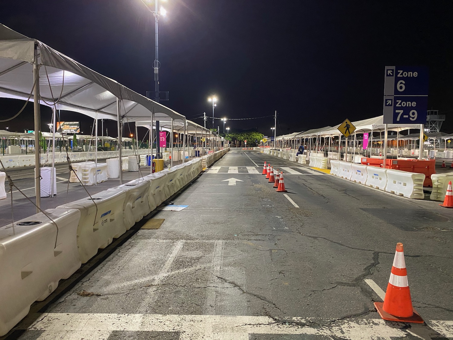 a road with white barriers and orange cones