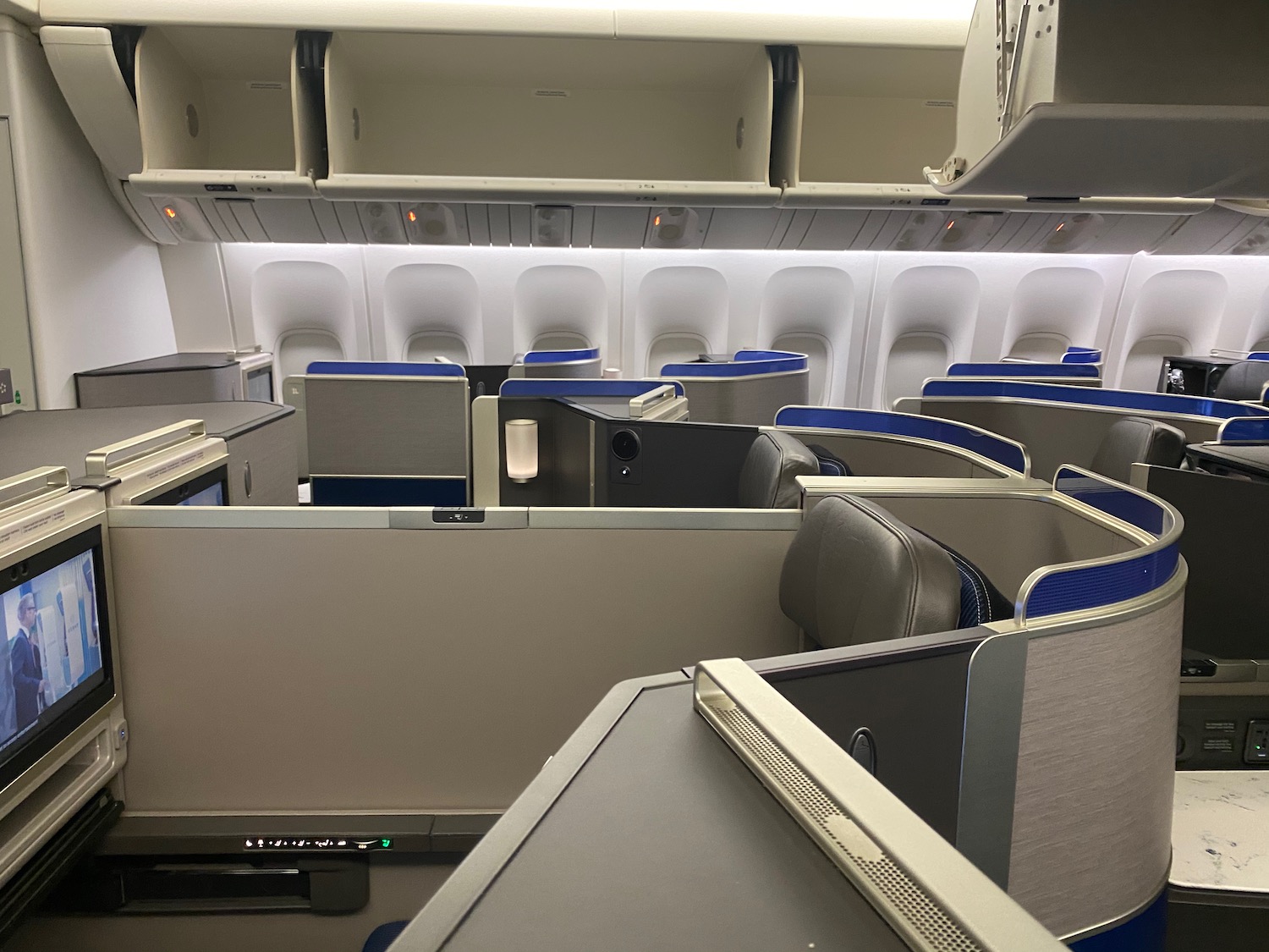 an airplane cabin with seats and a shelf