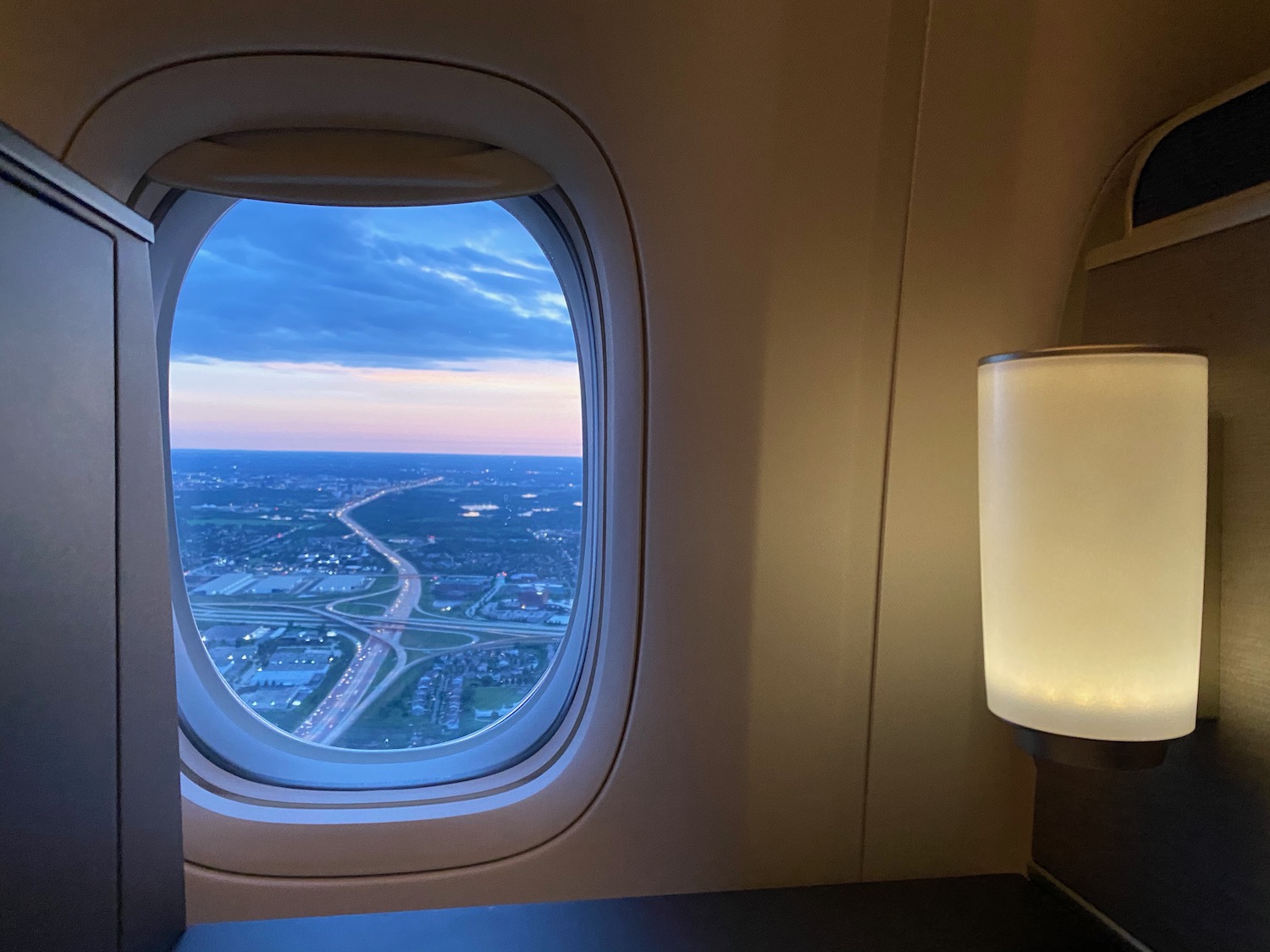 a window of an airplane with a view of a city