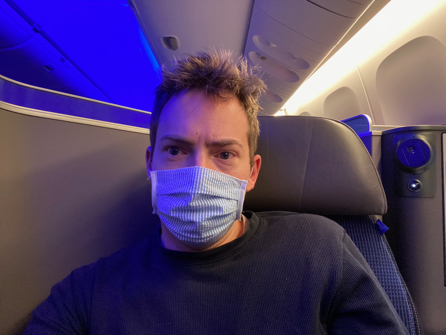 a man wearing a mask on an airplane