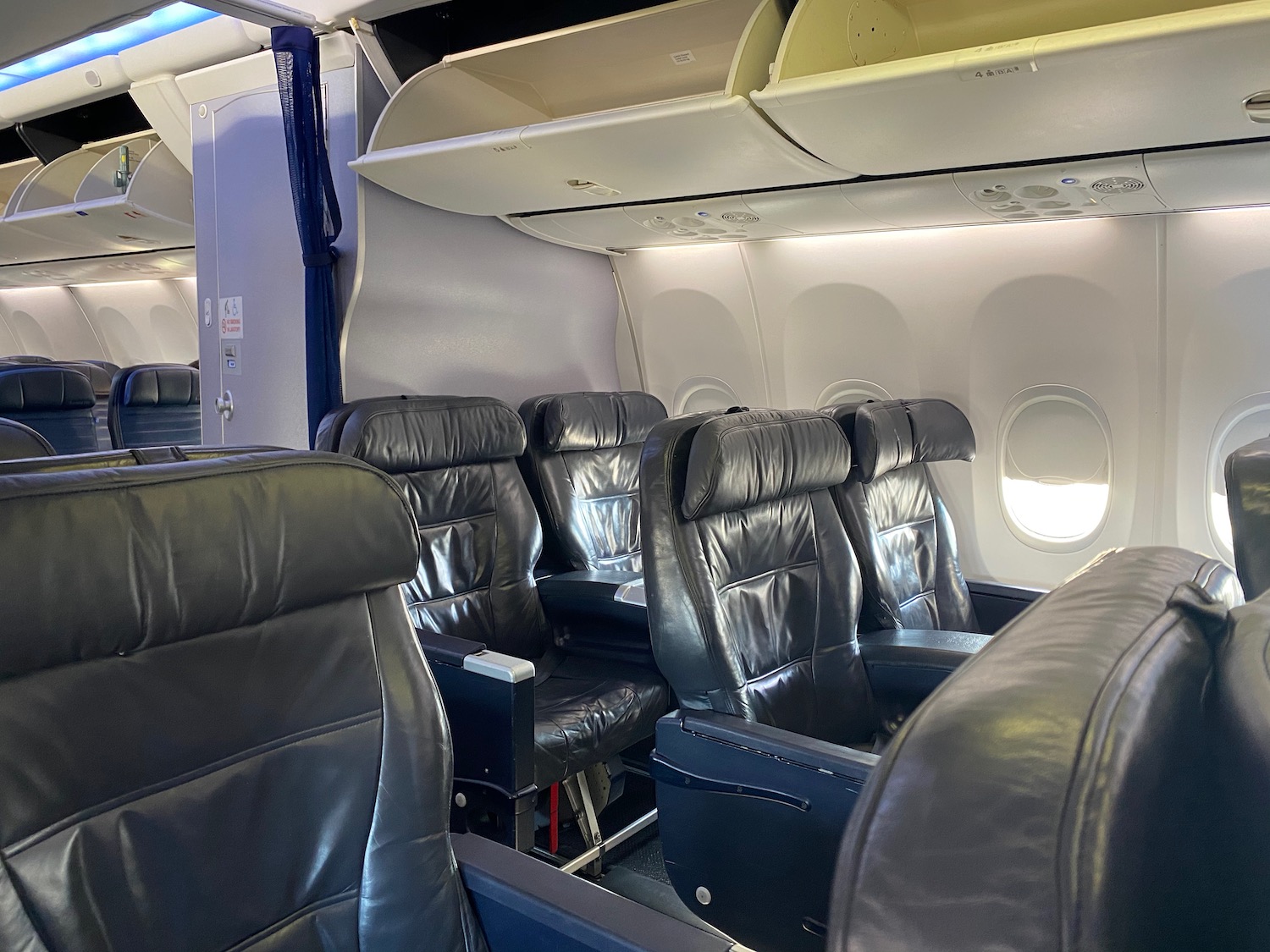 a row of black leather seats in an airplane