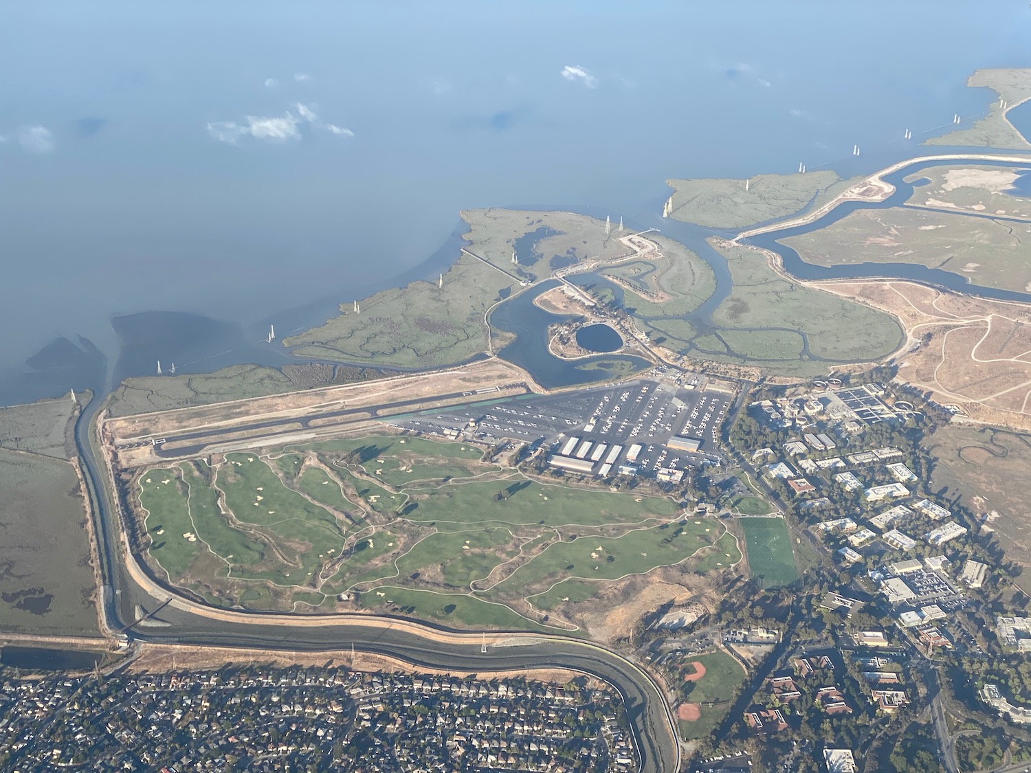 an aerial view of a land with a river and buildings