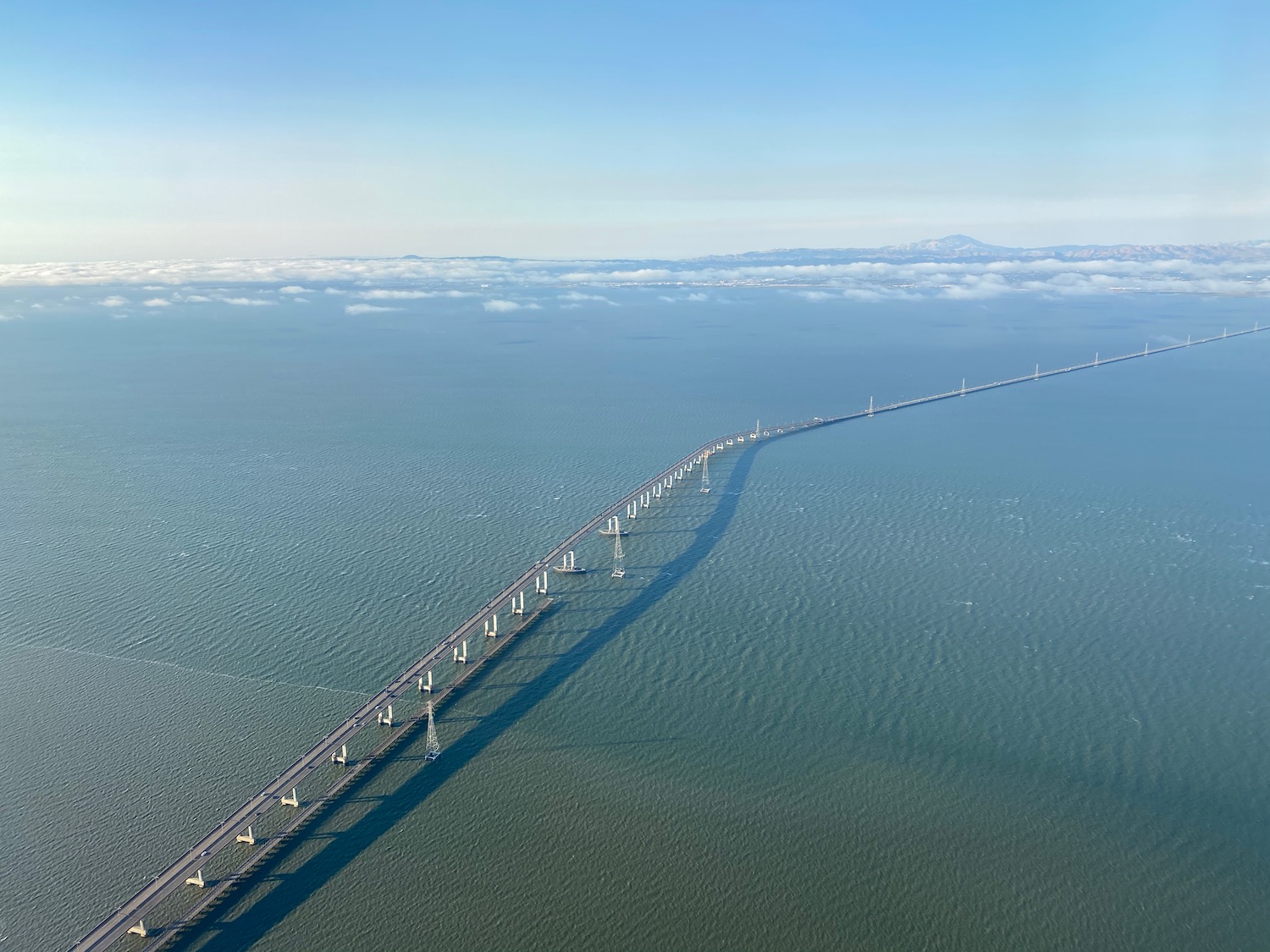 a bridge over water with clouds in the background