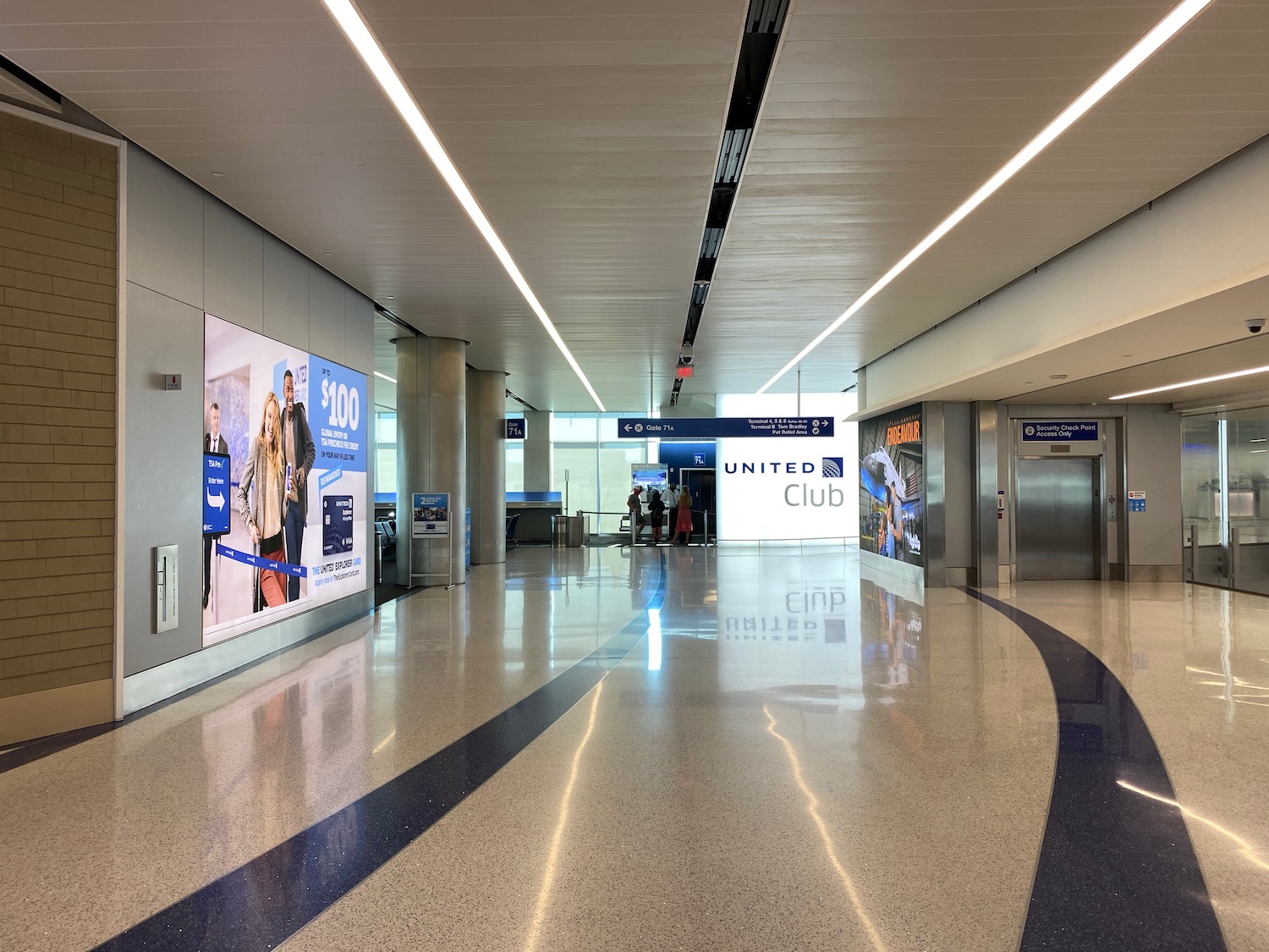 a hallway with signs and people walking in the middle