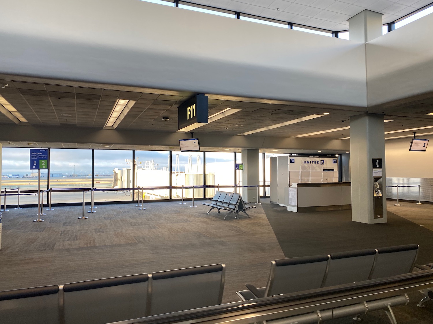 an airport terminal with chairs and a sign