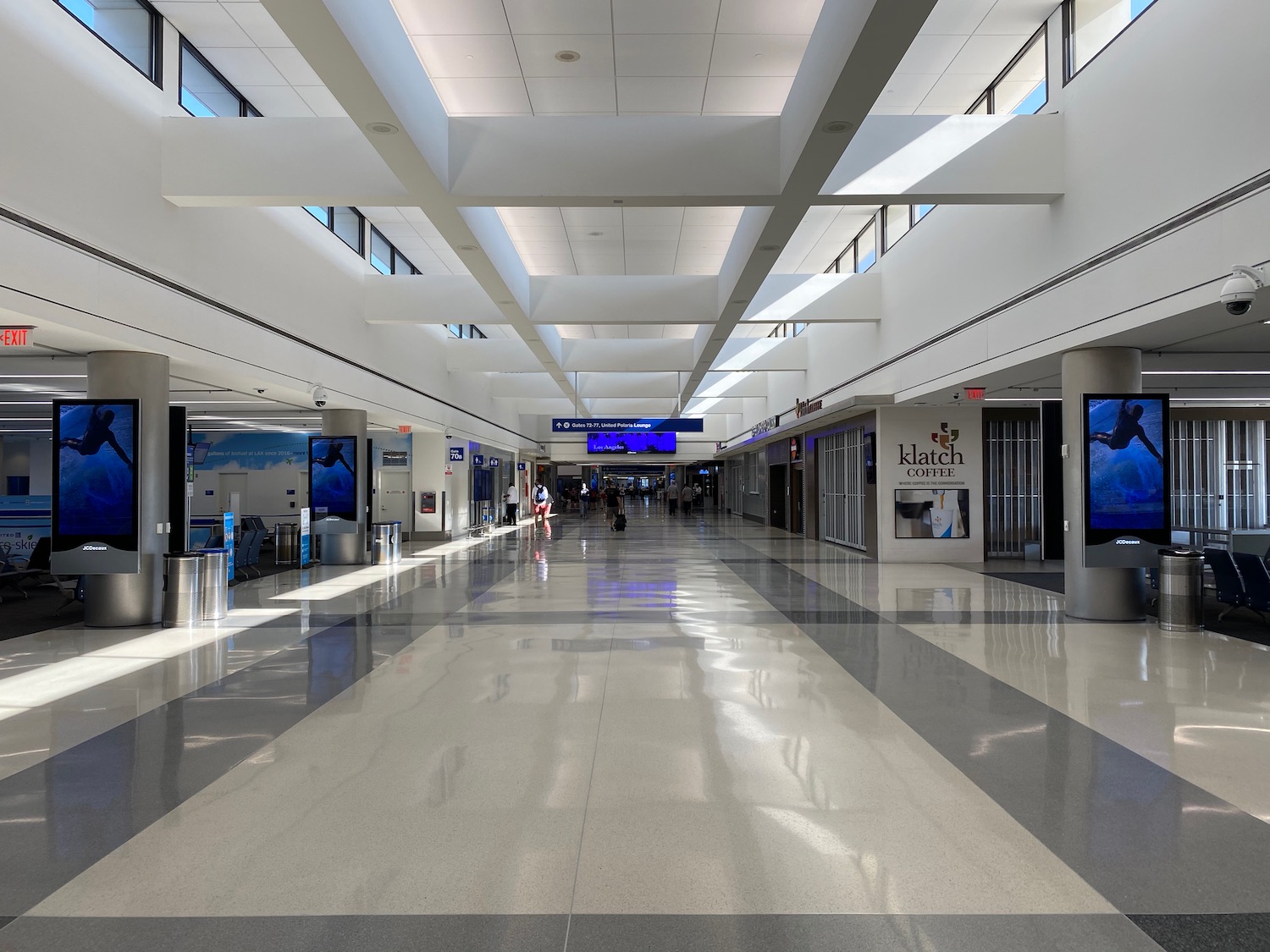 a large white hallway with people walking in it