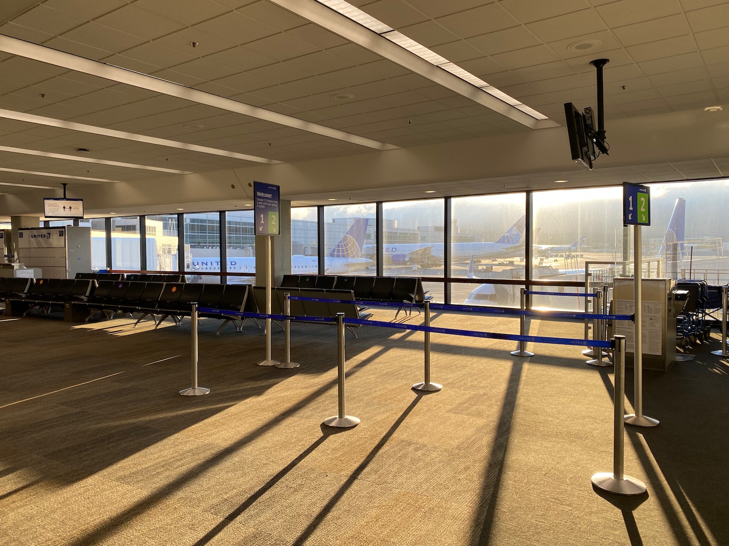 an airport terminal with rows of seats and a blue ribbon