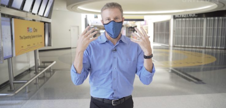 a man wearing a blue shirt and blue shirt with a face mask