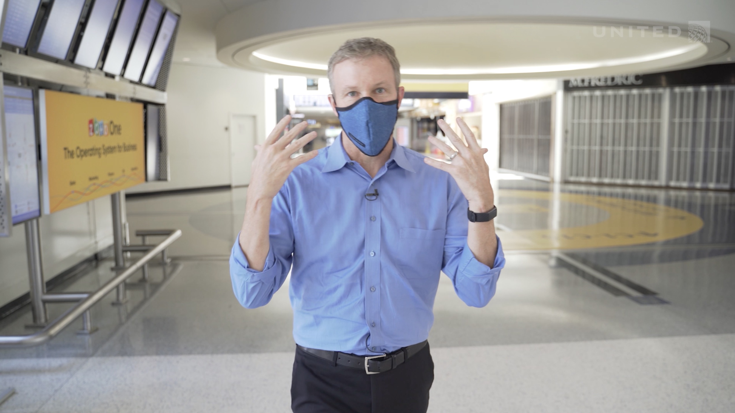 a man wearing a blue shirt and blue shirt with a face mask