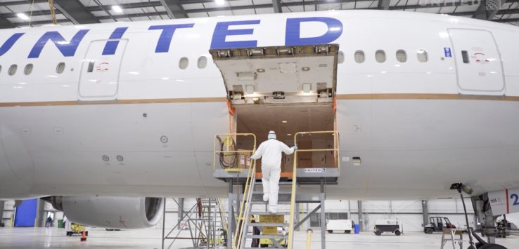 a man standing on a ladder next to an airplane