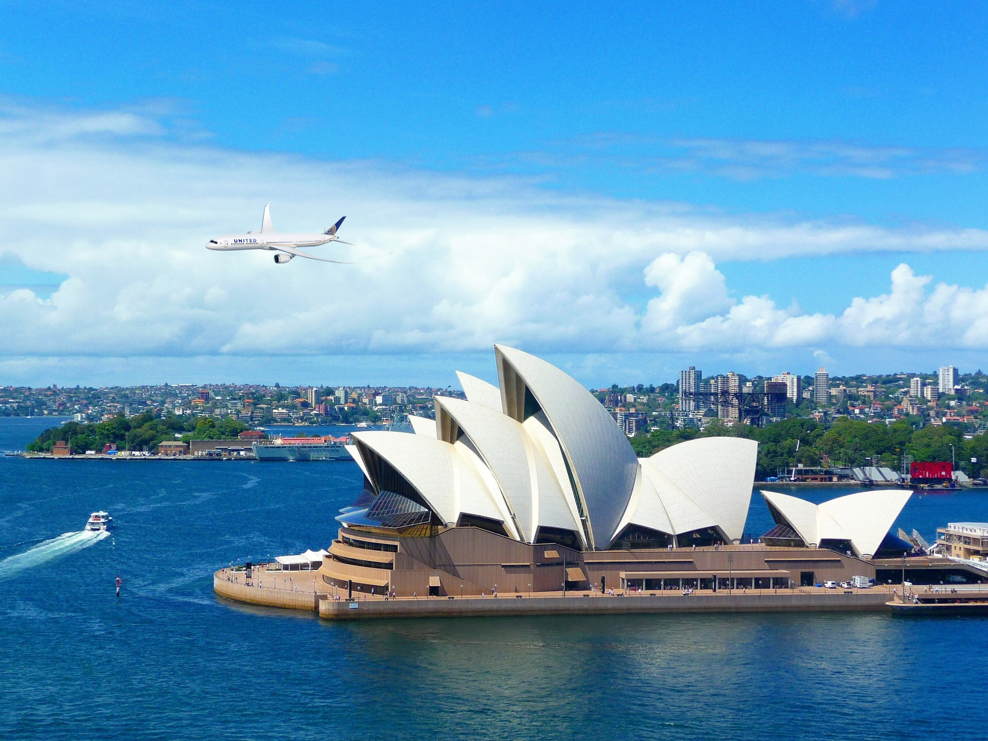 a plane flying over Sydney Opera House