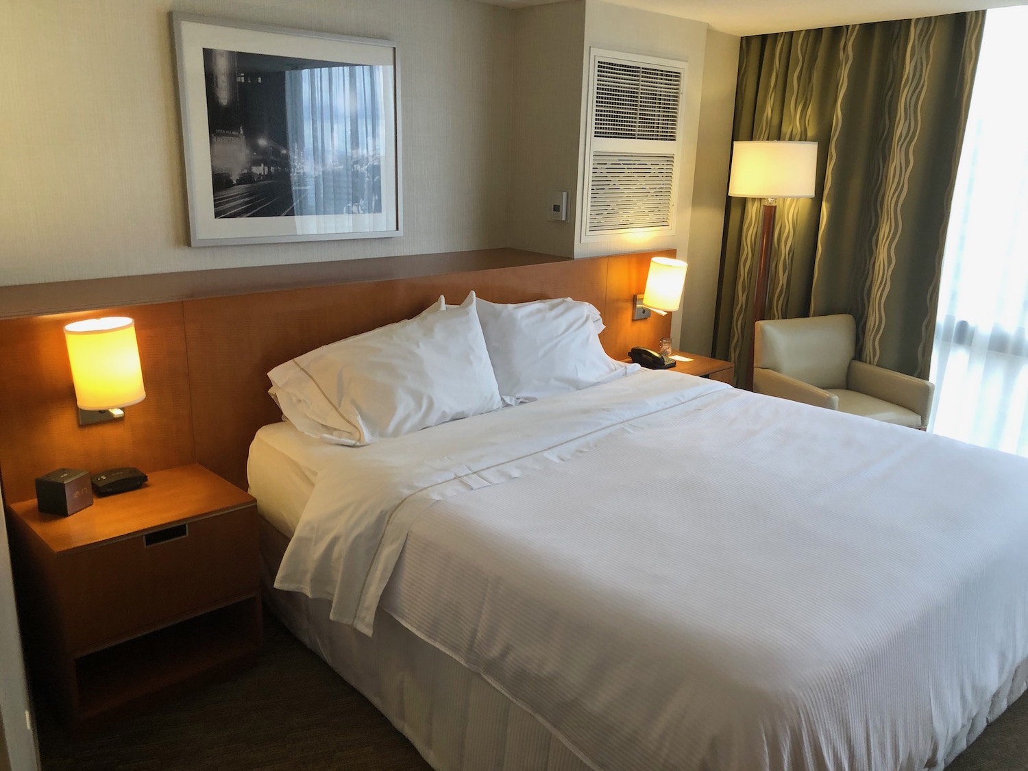 a bed with white sheets and lamps in a hotel room