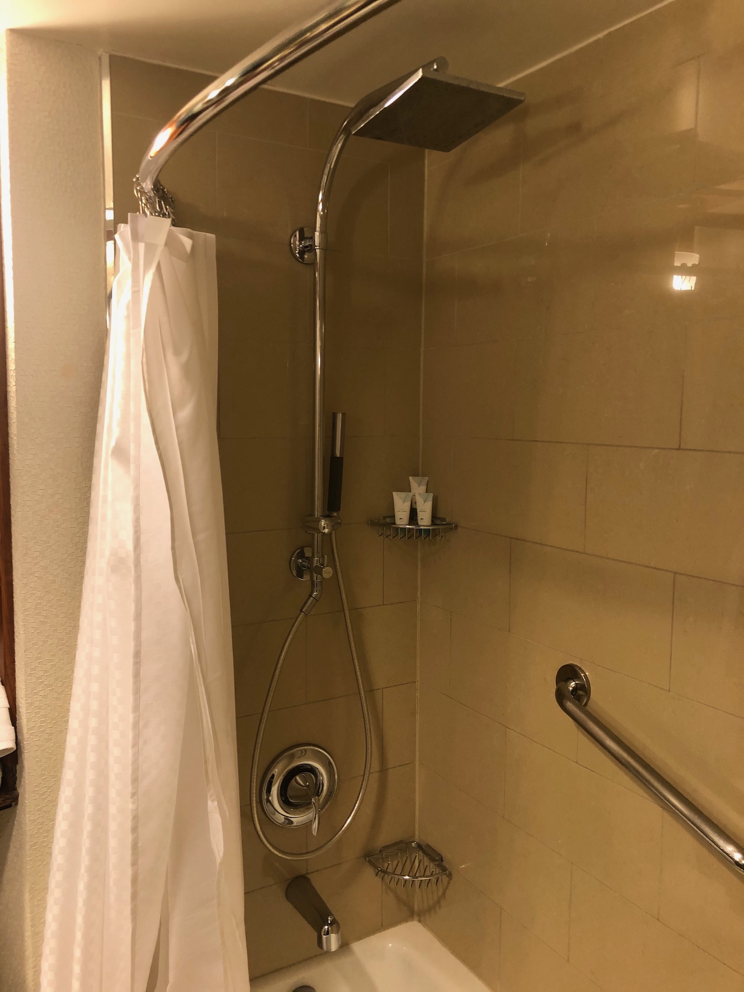 a shower with a shower head and a shower curtain
