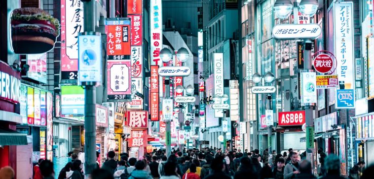 a crowd of people walking down a street with signs