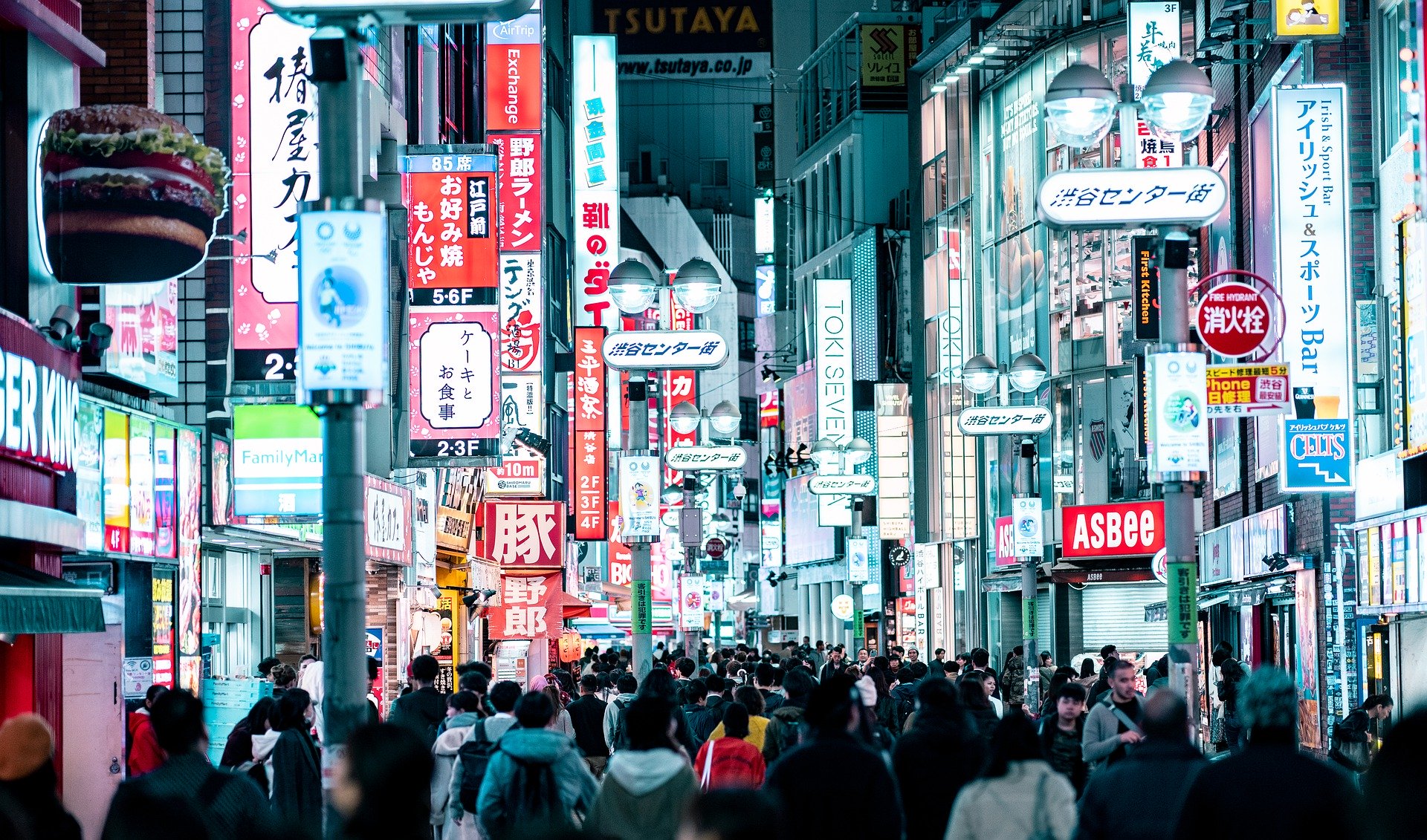 a crowd of people walking down a street with signs