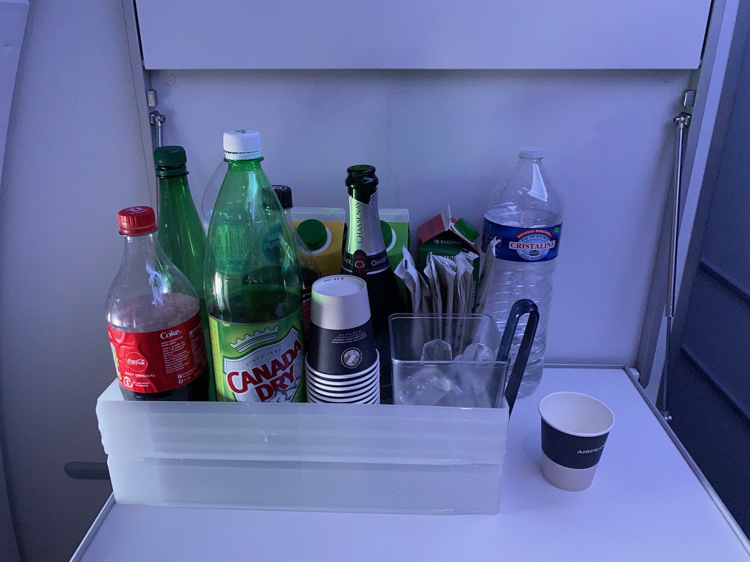 a plastic container with bottles and cups on a white surface
