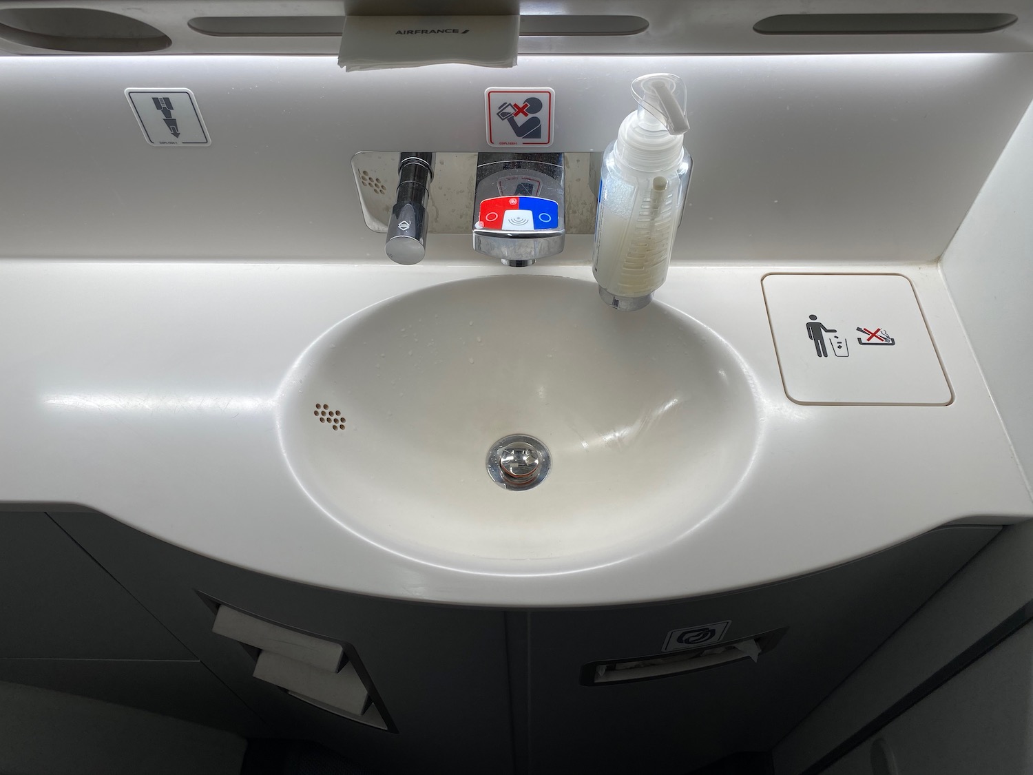 a sink with a soap dispenser and a bottle of liquid