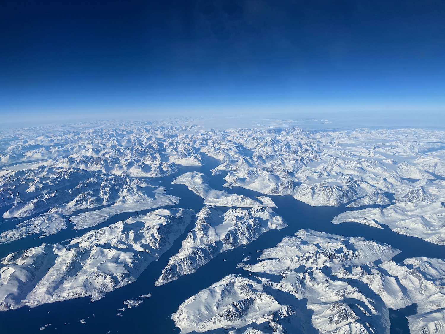 aerial view of snowy mountains and water