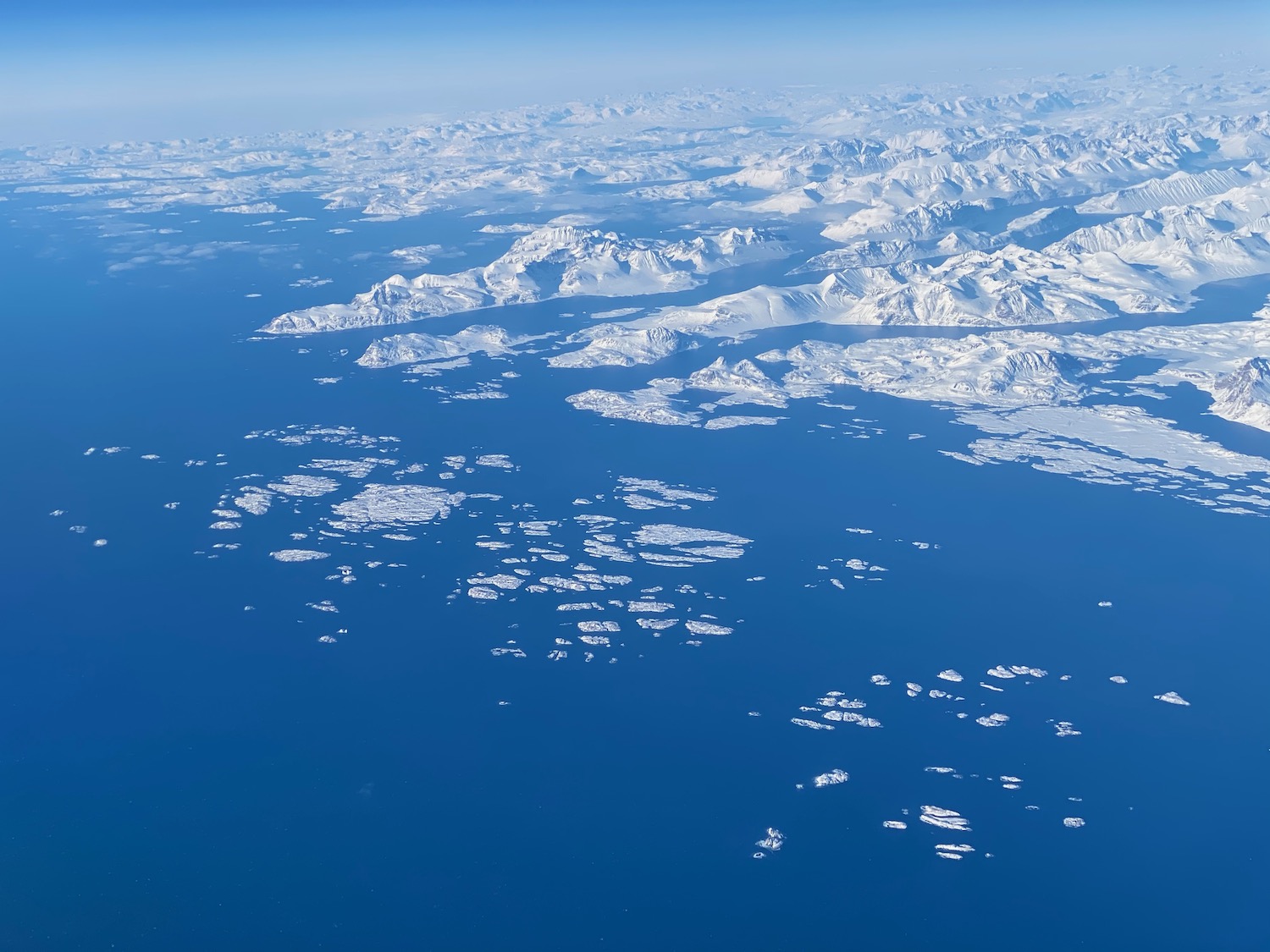 an aerial view of icebergs and water