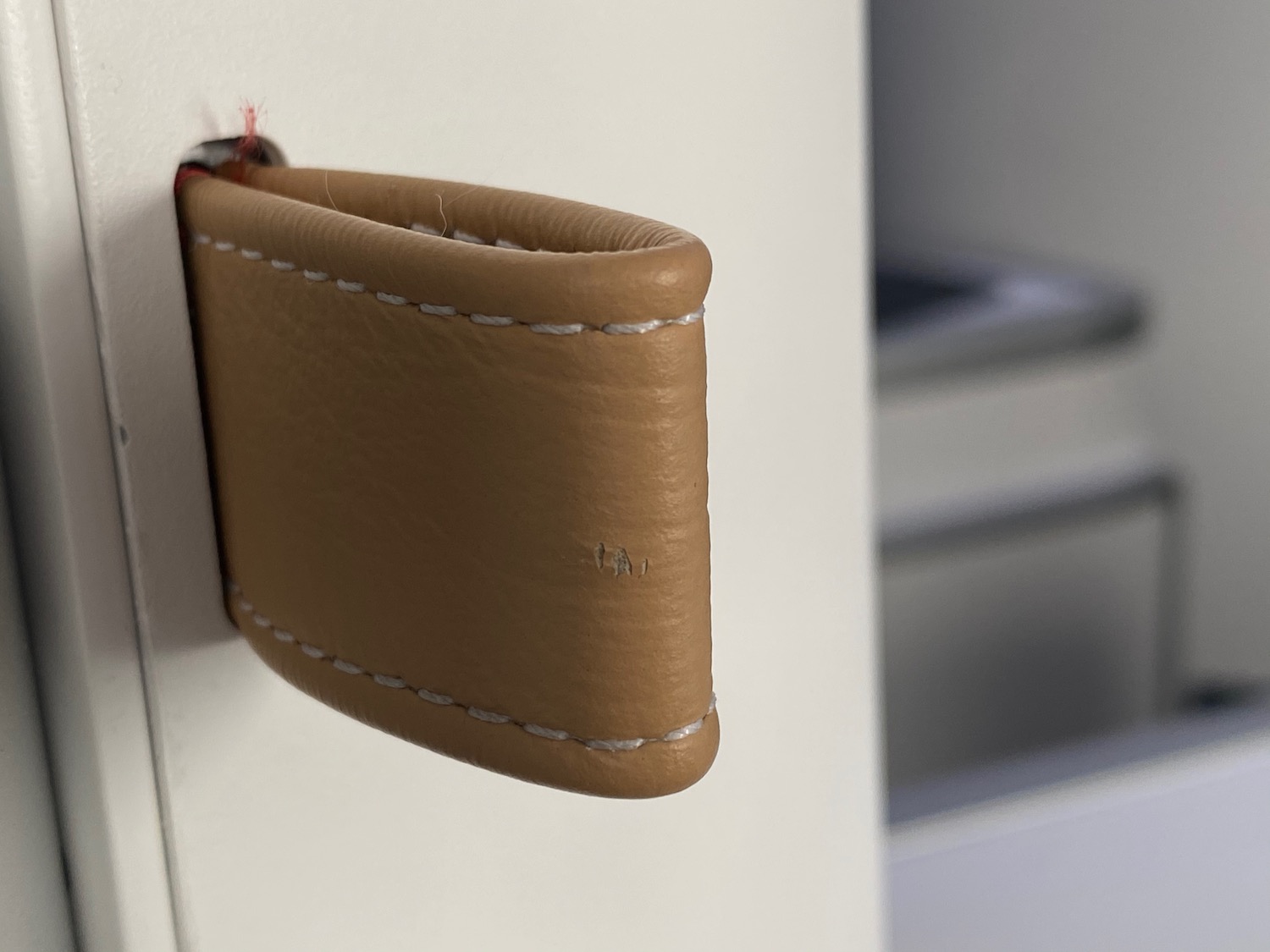 a brown leather object on a white surface