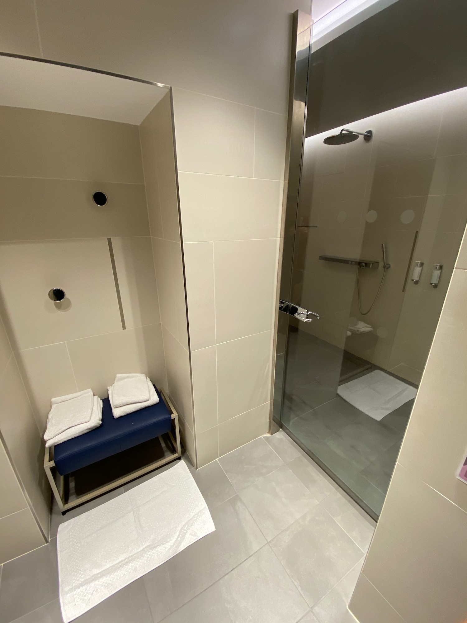 a shower with a bench and towels