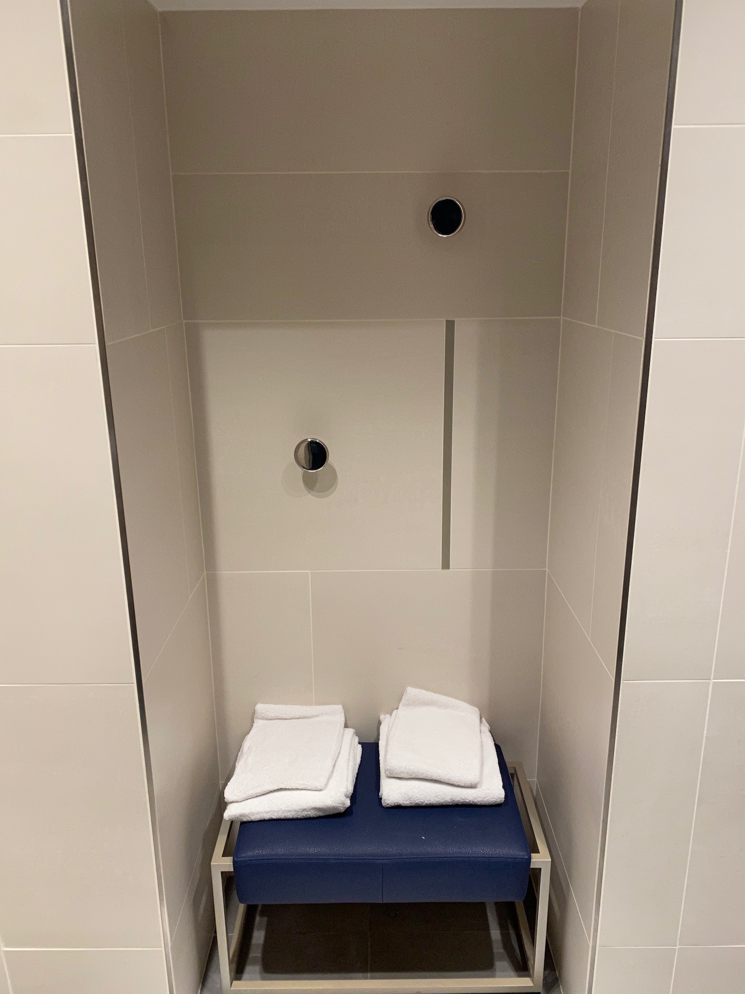 a shower with a blue box with white towels