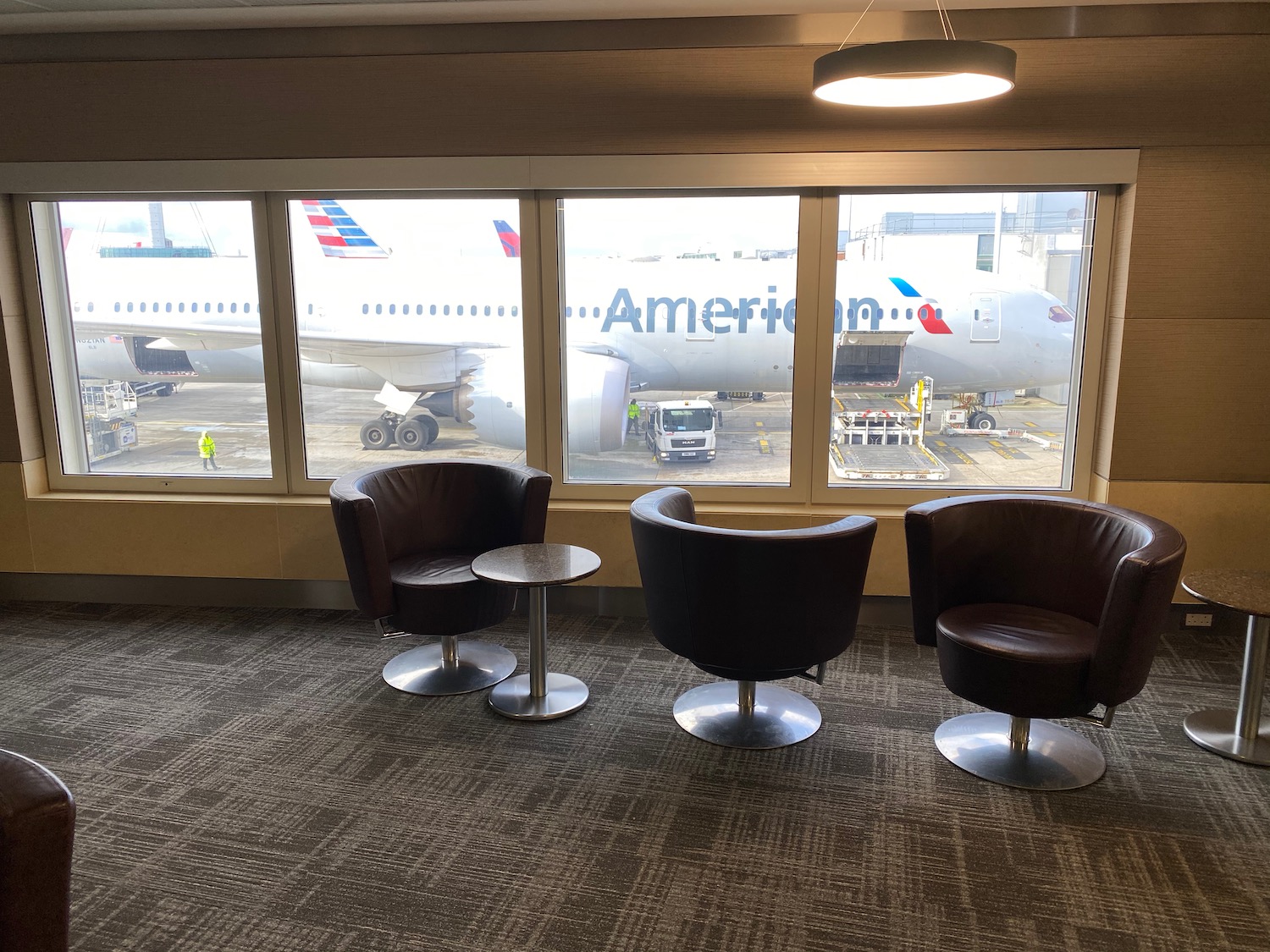 a group of chairs and tables in a room with windows